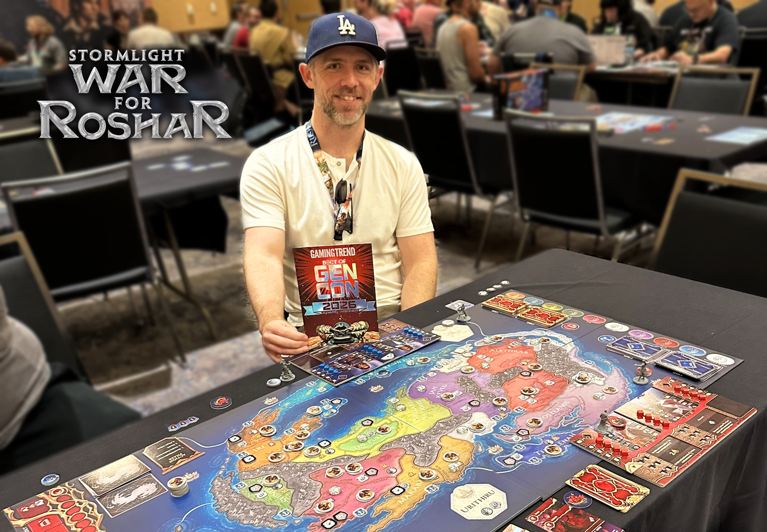 Stormlight: War for Roshar designer John D Clair standing beside a prototype and a GamingTrend Best of Gen Con 2026 award.