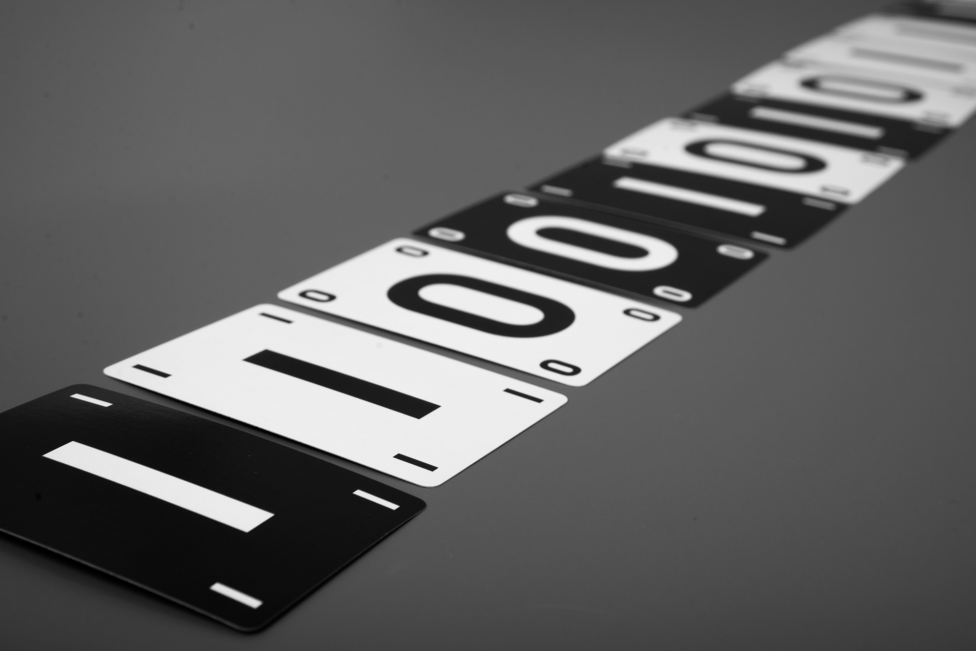 Black and white Compress cards laid in a long sequence on a gray table.