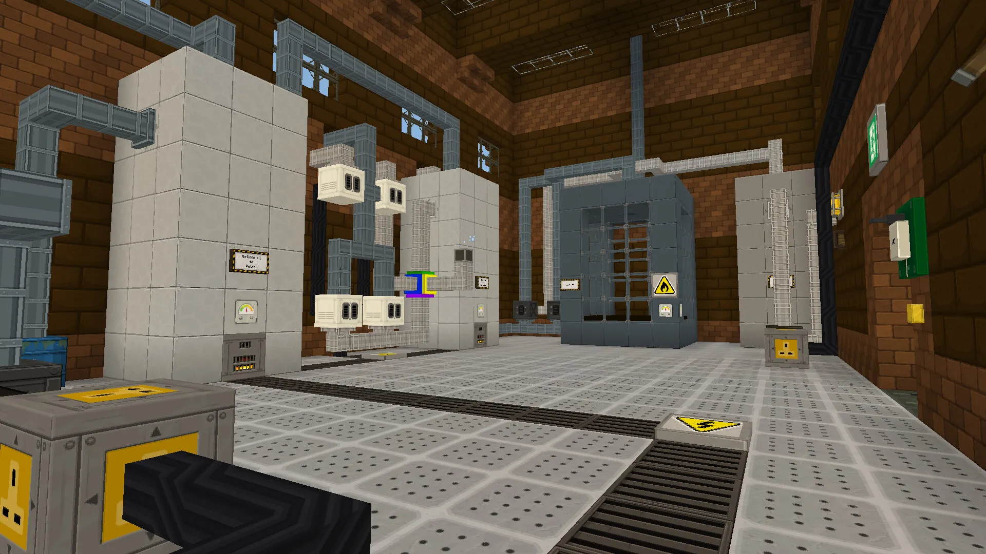 Machines and pipes inside a block-built industrial hall in Elsewhere.