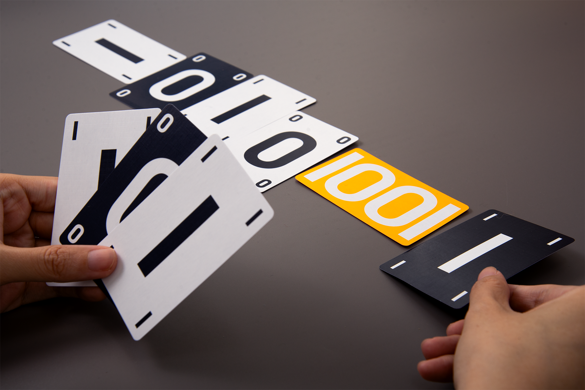 Compress number cards arranged on a table as a record of a binary sequence.