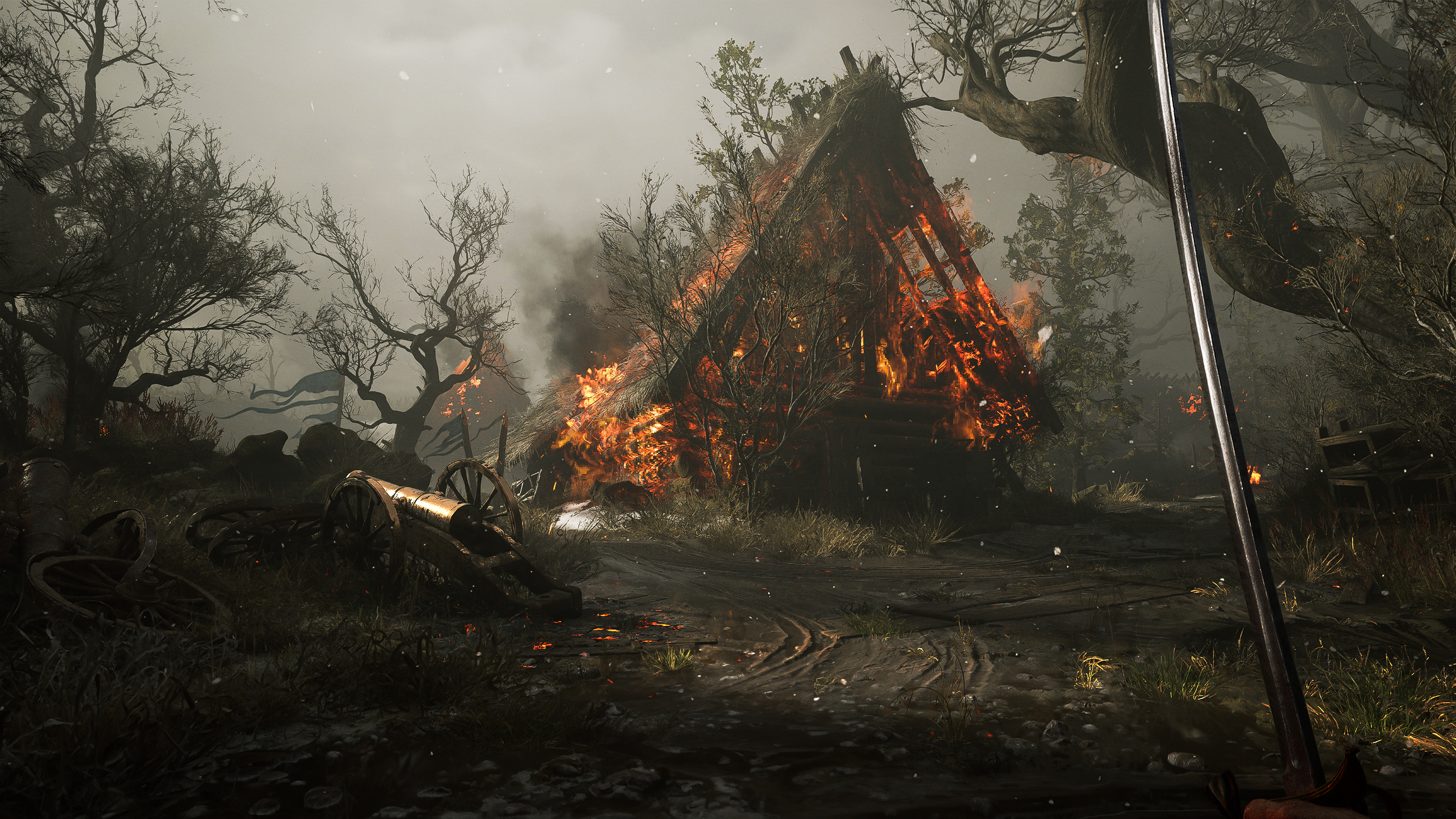 A burning timber house stands behind a damaged cart and cannon, with the player's blade at right.