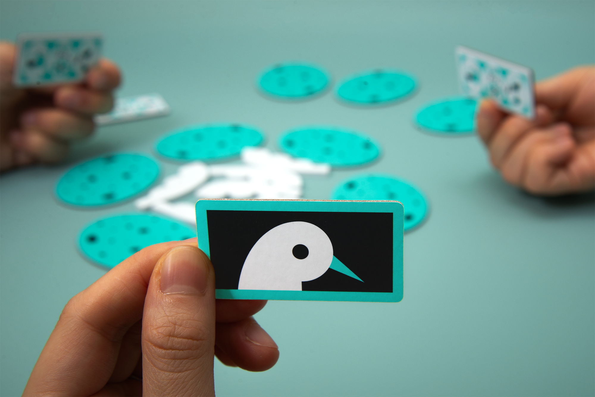 Hand holding a Bright Bird role card above a table of face-down Eggsposed egg tiles.