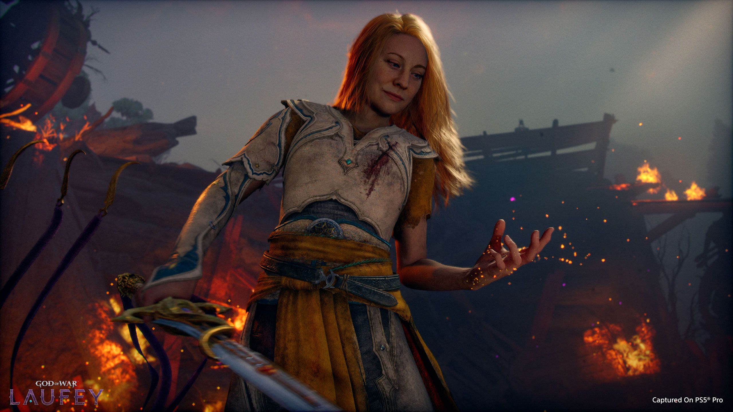 Official God of War: Laufey screenshot showing Faye in armor with a blood-streaked sword in a burning scene.