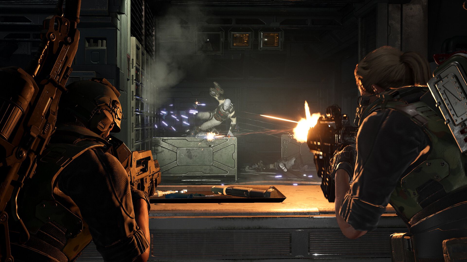 Official Aliens: Fireteam Elite 2 screenshot showing a four-player squad firing at a xenomorph rush inside a metallic arena.