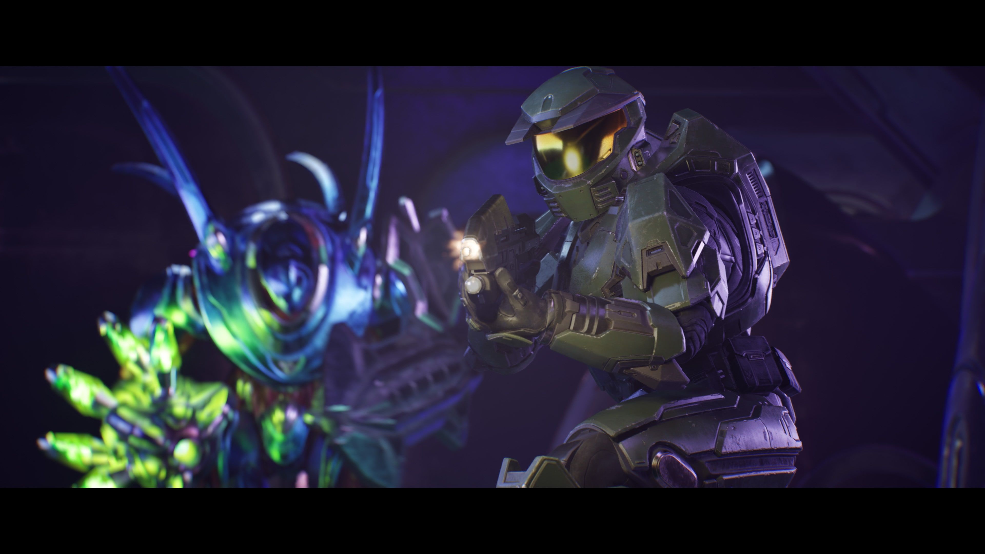 Official Halo: Campaign Evolved screenshot showing Master Chief facing a glowing alien enemy in a purple-lit interior.