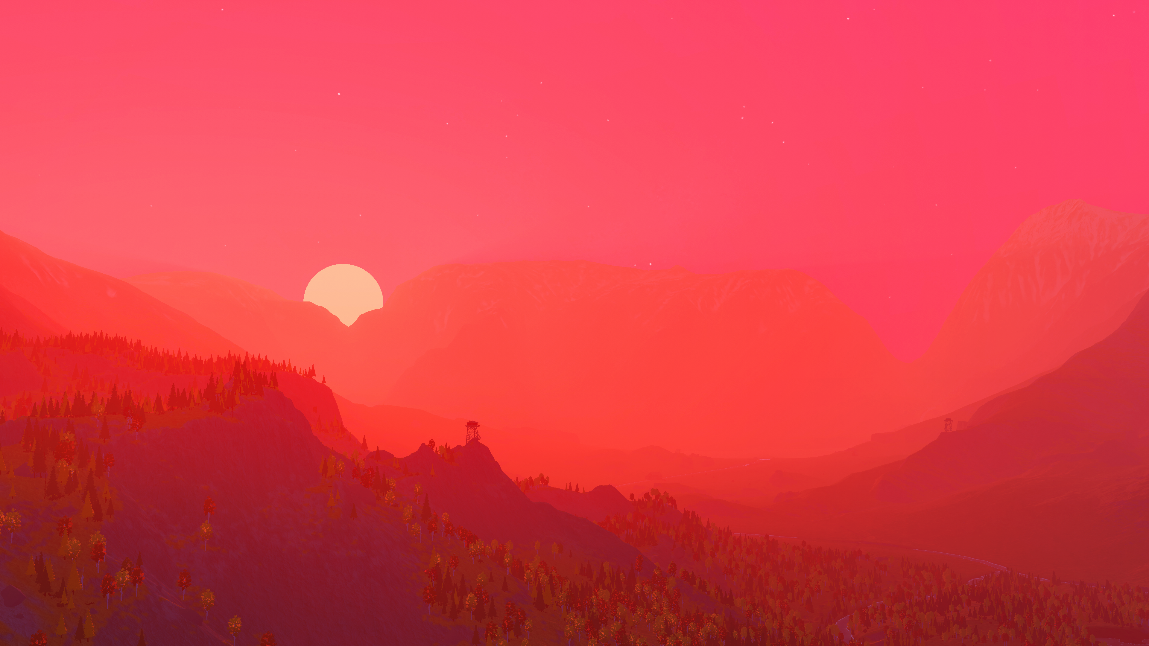 A broad red and pink sunset washes over a forested valley, cliffs and distant lookout towers.